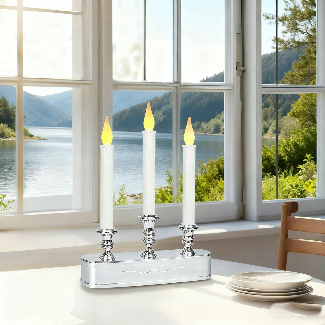 LED candle holder, silver base with three white taper candles on table by lake view window